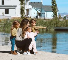 a group of young children standing next to a body of water