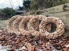 several pieces of wood stacked on top of each other in front of a pile of leaves