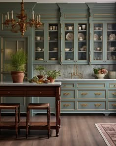 a kitchen filled with lots of green cabinets and counter top space next to a dining room table