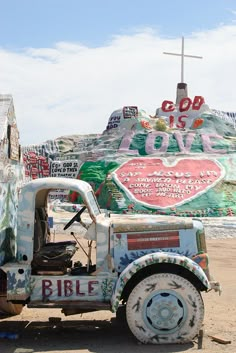 an old truck is parked in front of a large sign with the word bible written on it