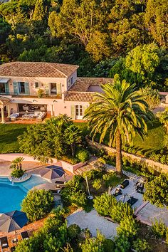 an aerial view of a house and pool surrounded by trees