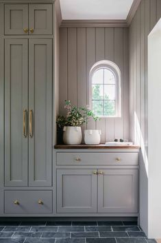 a kitchen with gray cabinets and white vases