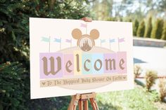 a welcome sign is displayed in front of some trees and bushes, with the words welcome to the happus baby show on earthly