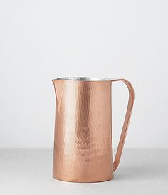 a copper colored pitcher sitting on top of a table