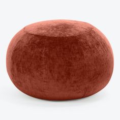 an orange velvet poufle on a white background, with no one in it