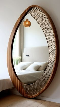 a mirror that is on the side of a wall next to a bed and window