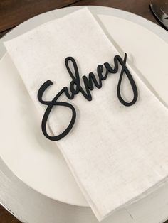 a white plate topped with a napkin and black lettering that says sorry on top of it