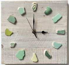 a clock made out of wood with green and white paint on the face is shown