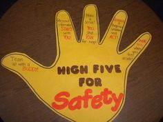 a sign that says high five for safety on a wooden table with writing in the middle