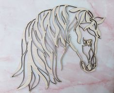 a wooden cutout of a horse's head on a pink marble table top