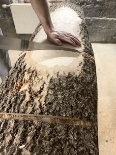 a man is cutting wood with a large knife