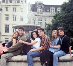 a group of people sitting on top of a fountain