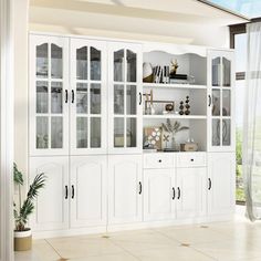 a white bookcase with glass doors in a room