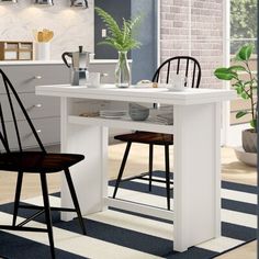 two black chairs sit at a white table in the middle of a room with blue and white striped rug