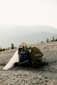 backpacks and wedding veil on the side of a mountain