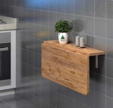 a potted plant sitting on top of a wooden shelf next to a wall oven