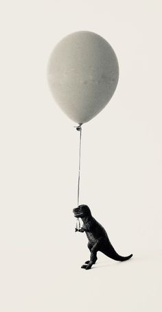 a t - shirt that is attached to a balloon in the shape of a dinosaur