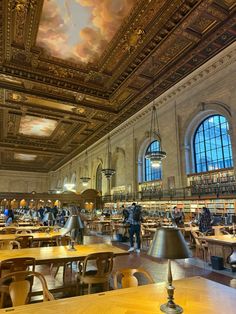 the interior of an old library with many tables and chairs in front of large windows