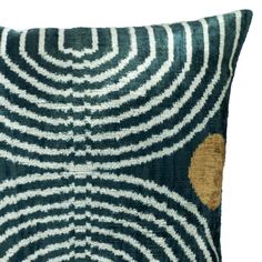 a blue and white pillow with an abstract design on the front, featuring gold dots