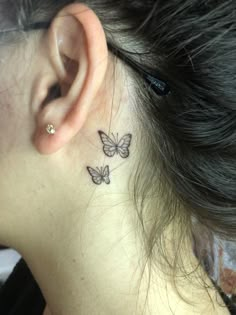 a woman's behind the ear tattoo with two butterflies on her left side neck