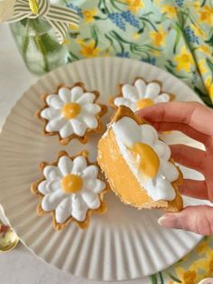 a hand holding a piece of pie on top of a paper plate with flower decorations