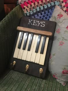 an old piano key case sitting on top of a couch next to pillows and a pillow