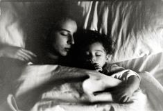 a woman and child laying in bed together