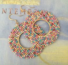 two pairs of beaded hoop earrings on top of a magazine cover with the title in french