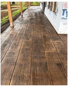 a porch with wood flooring next to a building