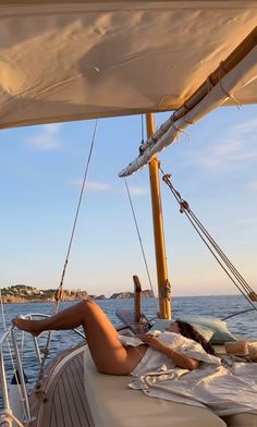 a woman laying on the deck of a sailboat