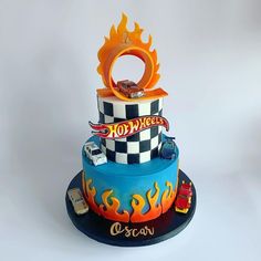 a three tiered cake with cars and flames on it's sides, in the shape of a ring