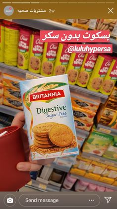 a person holding up a box of biscuits in front of a store shelf with other items