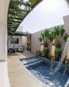 an indoor swimming pool surrounded by plants and water features a waterfall that flows from the ceiling to the floor