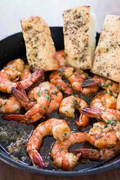 some shrimp and bread are in a skillet