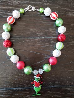 "How The Grinch Stole Christmas Inspired Children's Chunky Bubblegum Bead Necklace & Bracelet Set/ Holidays This very cute Christmas Grinch Necklace & Bracelet Set is a perfect addition to any holiday outfit and the holiday season. The Necklace is made up primarily of 20mm beads in shades of red, green and white. The necklace measures approximately 11\" when toggled around neck including the Grinch pendant. The Bracelet is an elastic bracelet, doubled up for extra strength. The Necklace Multicolor Round Beads Christmas Jewelry, Christmas Party Beaded Necklaces With Round Beads, Christmas Party Round Bead Necklaces, Festive Christmas Beads With Round Shape, Festive Christmas Beads, Christmas Festive Round Beads, Christmas Gift Beaded Necklaces With Round Beads, Christmas Holiday Necklace With Round Beads, Cute Handmade Christmas Jewelry