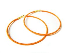 "Add some sunshine to your wardrobe with these orange hoop earrings! Tired of the usual gold and silver hoops?  These might just be for you!  Just in time to brighten up your summer wardrobe, these big orange hoops are bound to make you smile. Created using a technique called thread wrapping, bright orange embroidery thread is painstakingly wrapped around the gold coloured hoop base.  The thread is secured using jewellers adhesive to ensure your earrings can be enjoyed for years to come!   These Affordable Small Hoop Orange Earrings, Interesting Earrings, Orange Embroidery, Hoop Earrings Large, Earring Fashion, Wrapped Earrings, Egyptian Jewelry, Topaz Necklace, Jewellery Uk