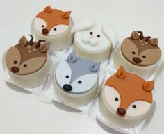 six decorated cupcakes in the shape of foxes and raccoon faces on top of each other