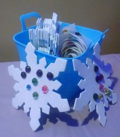 two snowflakes sitting on top of a table next to each other with toothbrushes in them