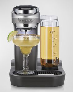 a drink dispenser with a glass next to it and a bottle filled with liquid