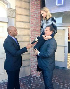 a man in a suit and tie is being interviewed by a woman wearing a striped shirt