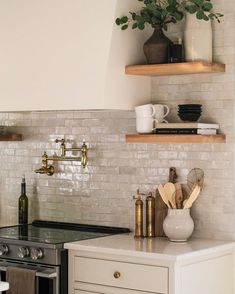 a kitchen with white brick walls and open shelving above the stove, surrounded by wooden shelves