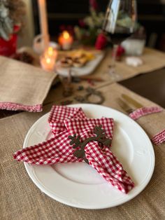 a white plate topped with red and white napkins next to a christmas tree ornament