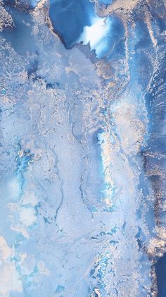 an aerial view of blue and white paint in the water with ice flakes on it