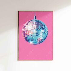 a pink wall with a mirror ball hanging from it's side, against a white wall