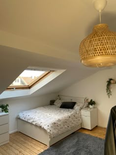 an attic bedroom with a bed, nightstands and plants on the floor in front of it