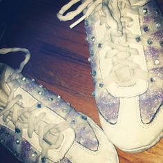 a pair of white sneakers with purple and silver sequins