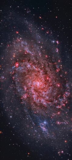 an image of a spiral galaxy with stars in the background and red light at the center