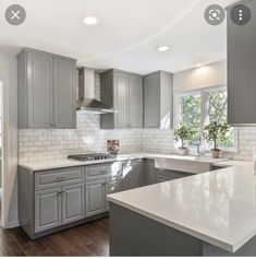 a large kitchen with gray cabinets and white counter tops is pictured in this image from the inside