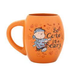 an orange coffee mug with a cartoon character on the side and words so cute it's scary