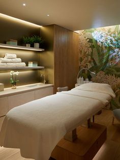 a spa room with white towels on the back of it's tables and shelves